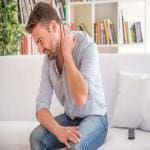 Depression can causes aches and pains. Man rubbing his neck in pain