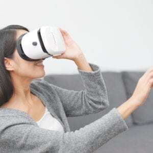 woman holding a virtual reality headset in therapy