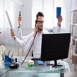 a manic man multitasking at work. In a manic state, individuals feel they are able to get a lot done
