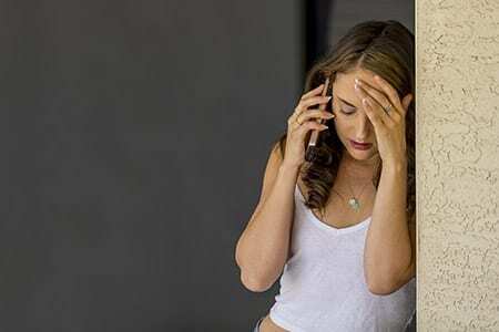 college woman on cell phone depressed