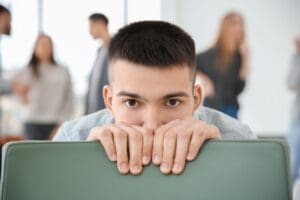 Young male worrying about social anxiety situation around him