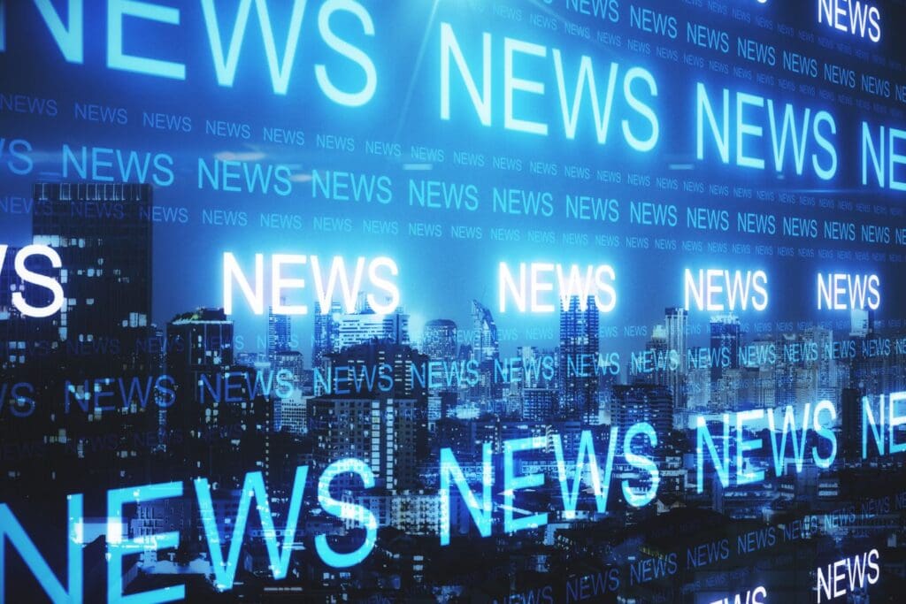 Close-up of a laptop displaying a polygonal network map over a blurred breaking news background, illustrating how constant news exposure can trigger stress responses, explained by Ginny Estupinian, PhD.