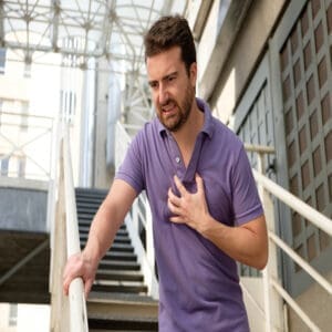 Image of a man clutching his chest in pain, depicting the physical symptoms of anxiety, such as chest tightness or discomfort
