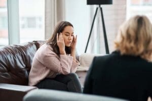Photo of a young woman discussing her concerns with a psychologist, symbolizing therapy and mental health support
