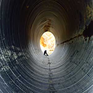 Image illustrating the feeling of being stuck in life caused by trauma and PTSD, symbolized by being trapped in a dark tunnel