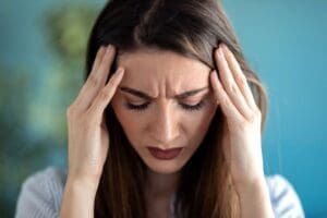 Photo of a young woman with a headache due to depression.