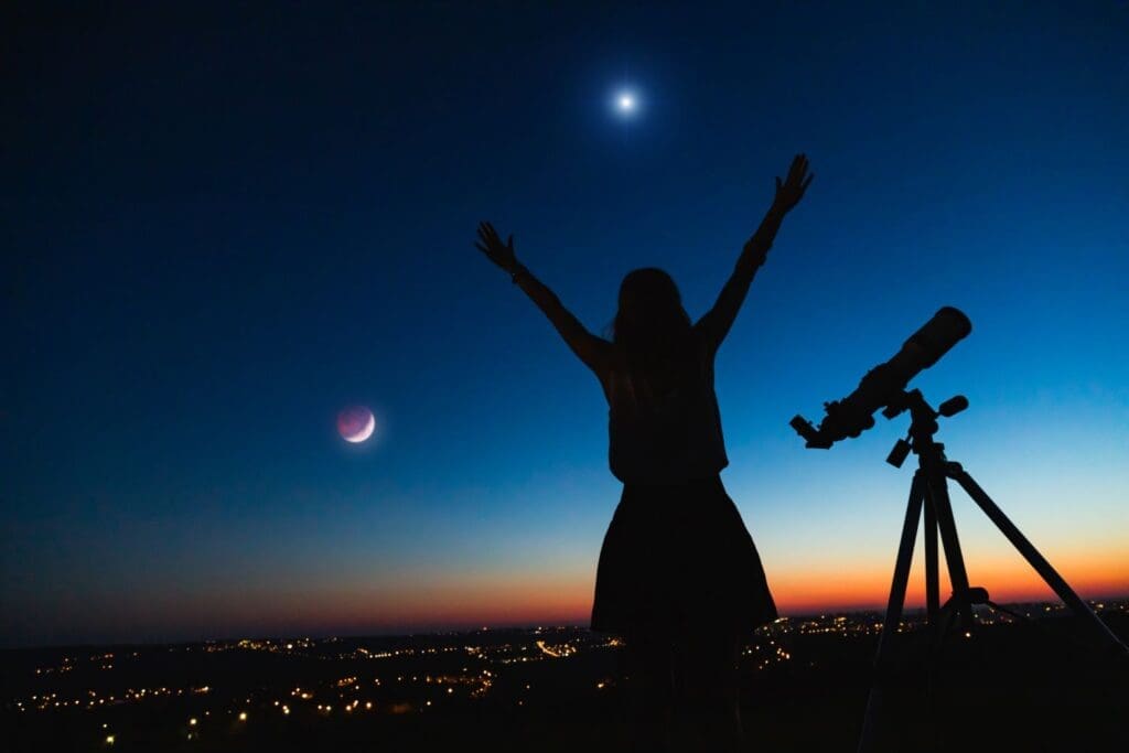 Photo of a woman with a telescope looking into the wonders of a solar eclipse